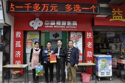 宋伟明和杨玉琴副主任为投注站业主送上慰问品