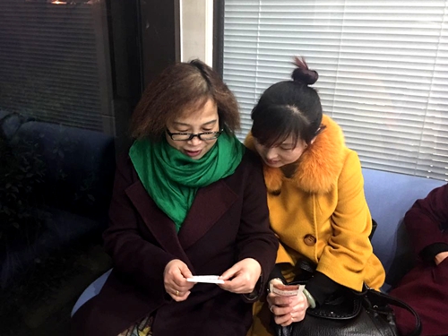 于女士（左）与她的朋友研究开奖号码