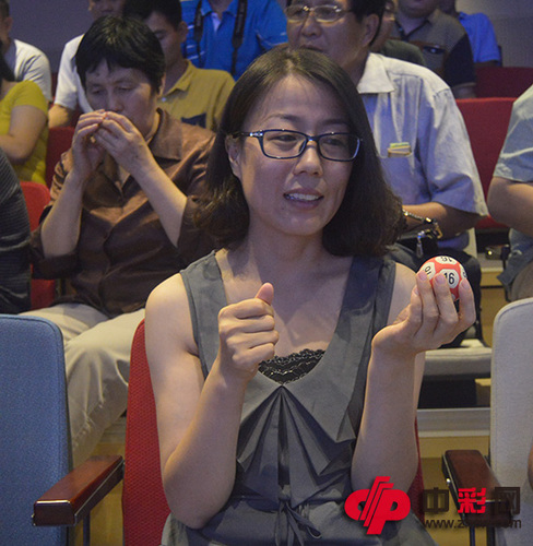 图六：刘女士与“退役”摇奖用球合影